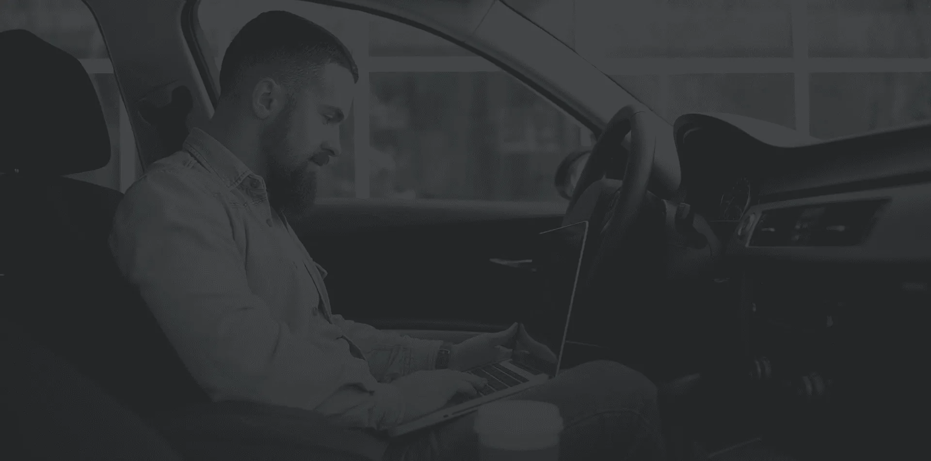 Person in the car checking his laptop