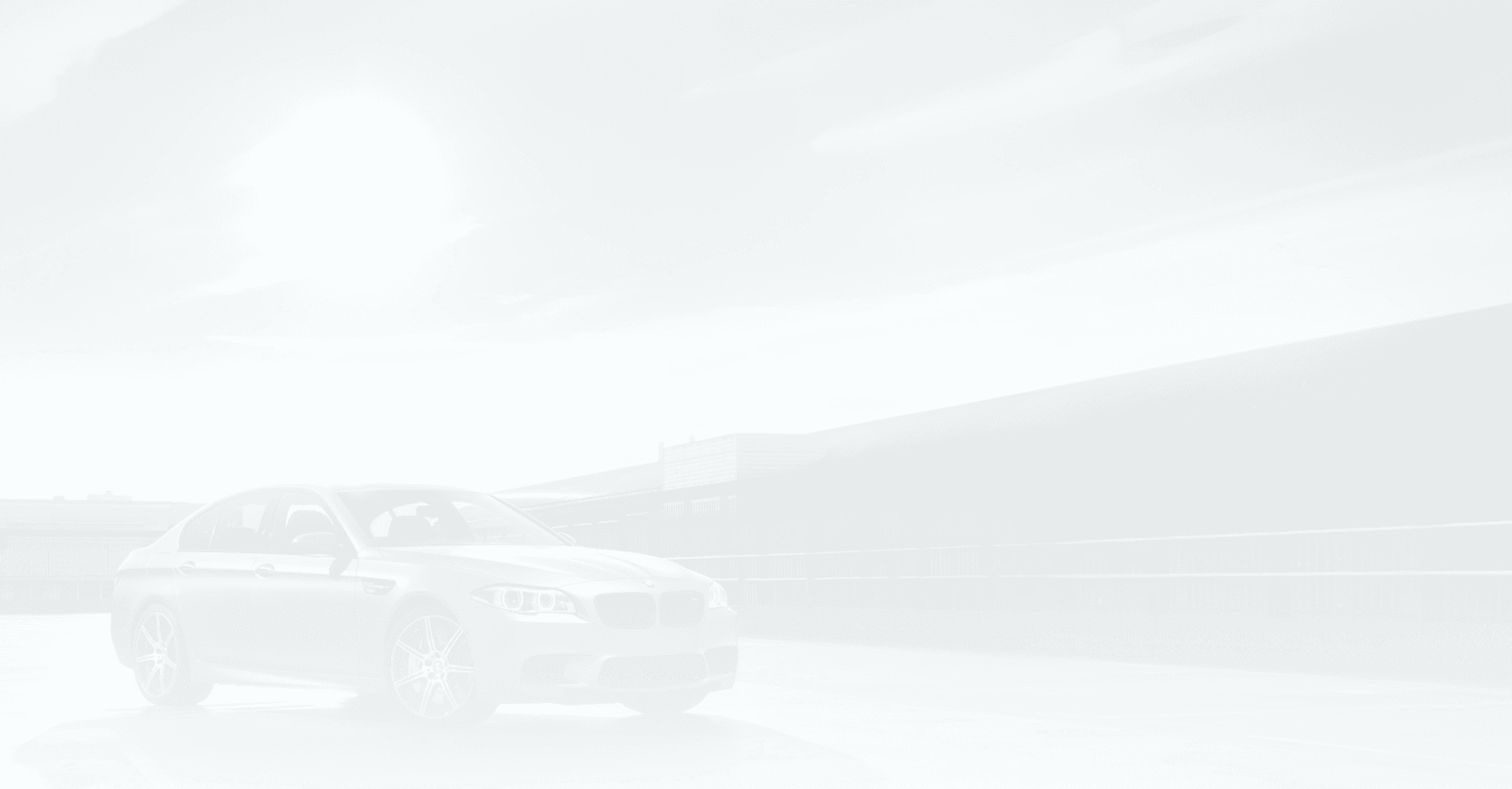 Dunkelgraue BMW Limousine vor einem modernen Industriegebäude